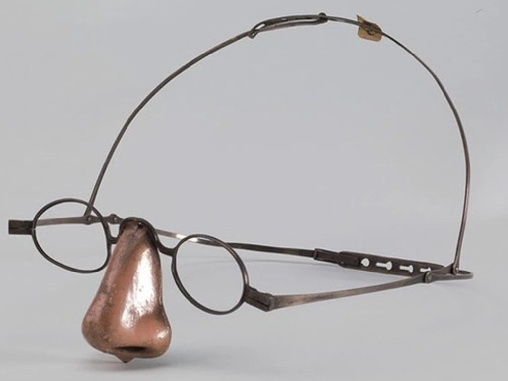 A pair of glasses with a metal nose attached