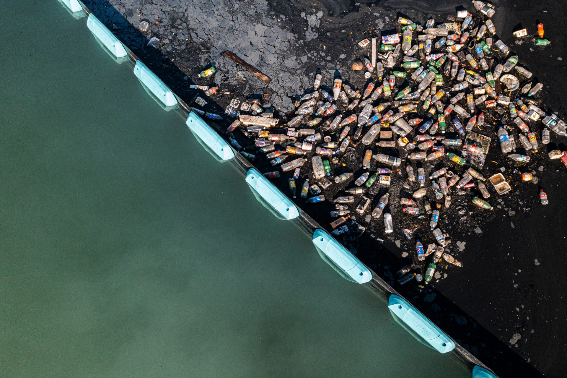 A barrier catching plastic bottles before they enter the ocean
